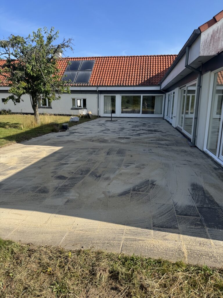 Rensede fliser efter ukrudtsfjernelse og nyt fugesand udført af LamaFixit